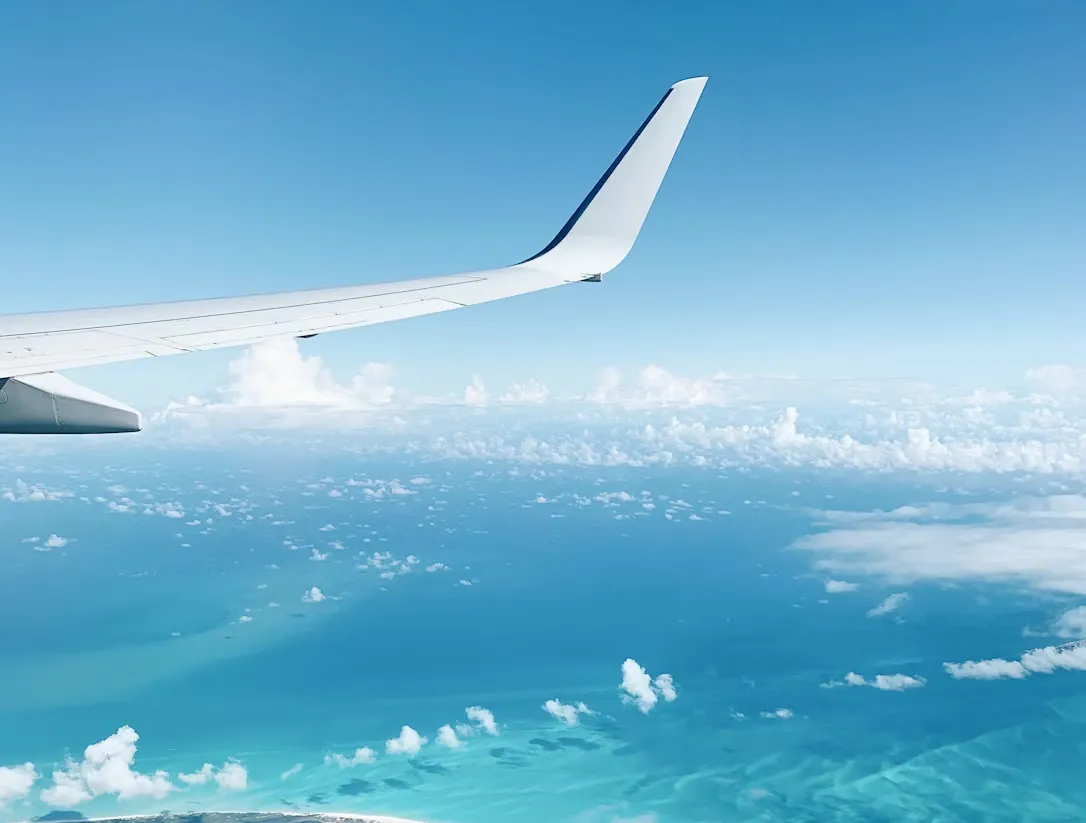 Airplane wing view above clouds